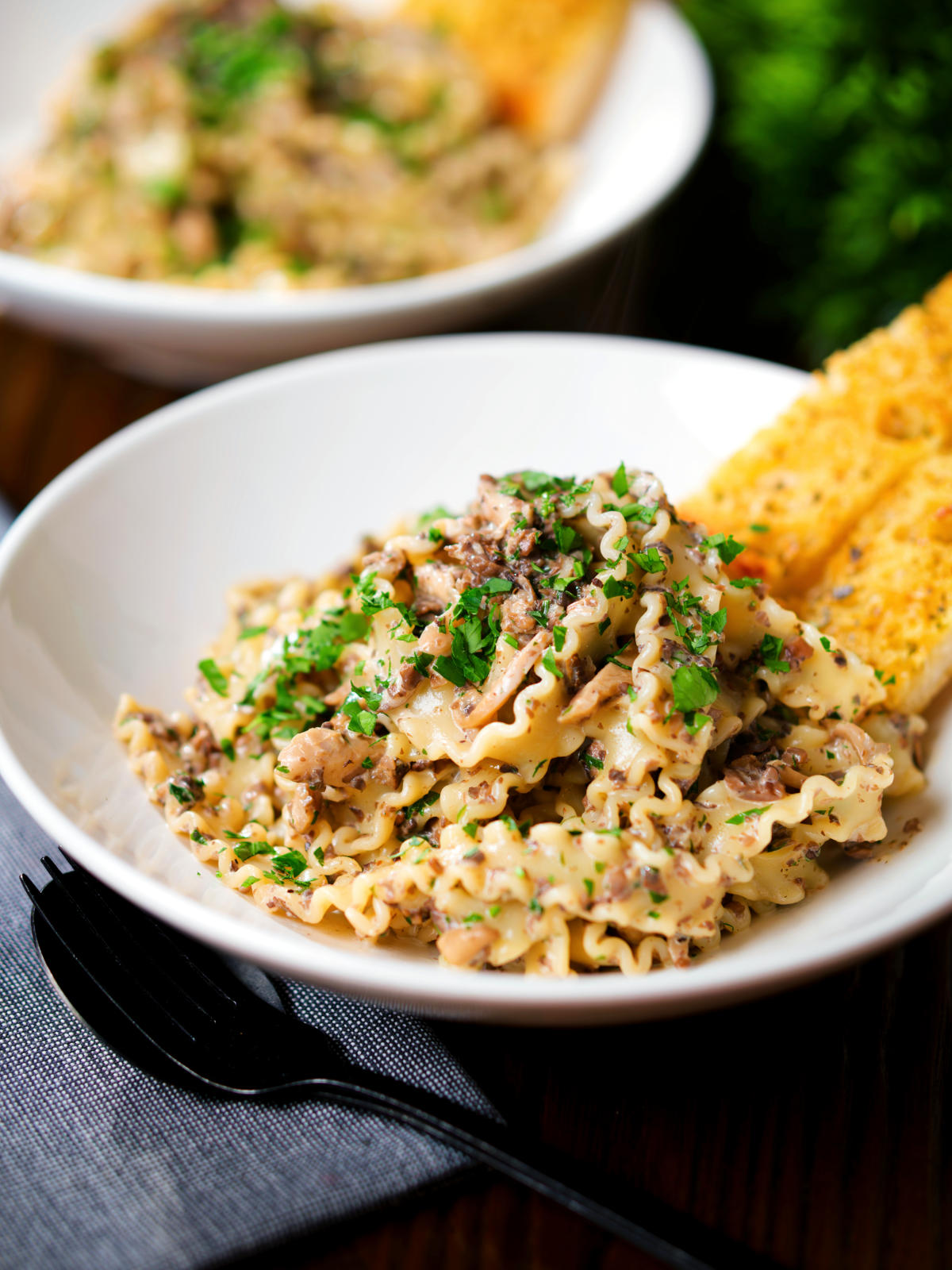 Creamy garlic mushroom pasta served with fresh parsley and garlic bread.