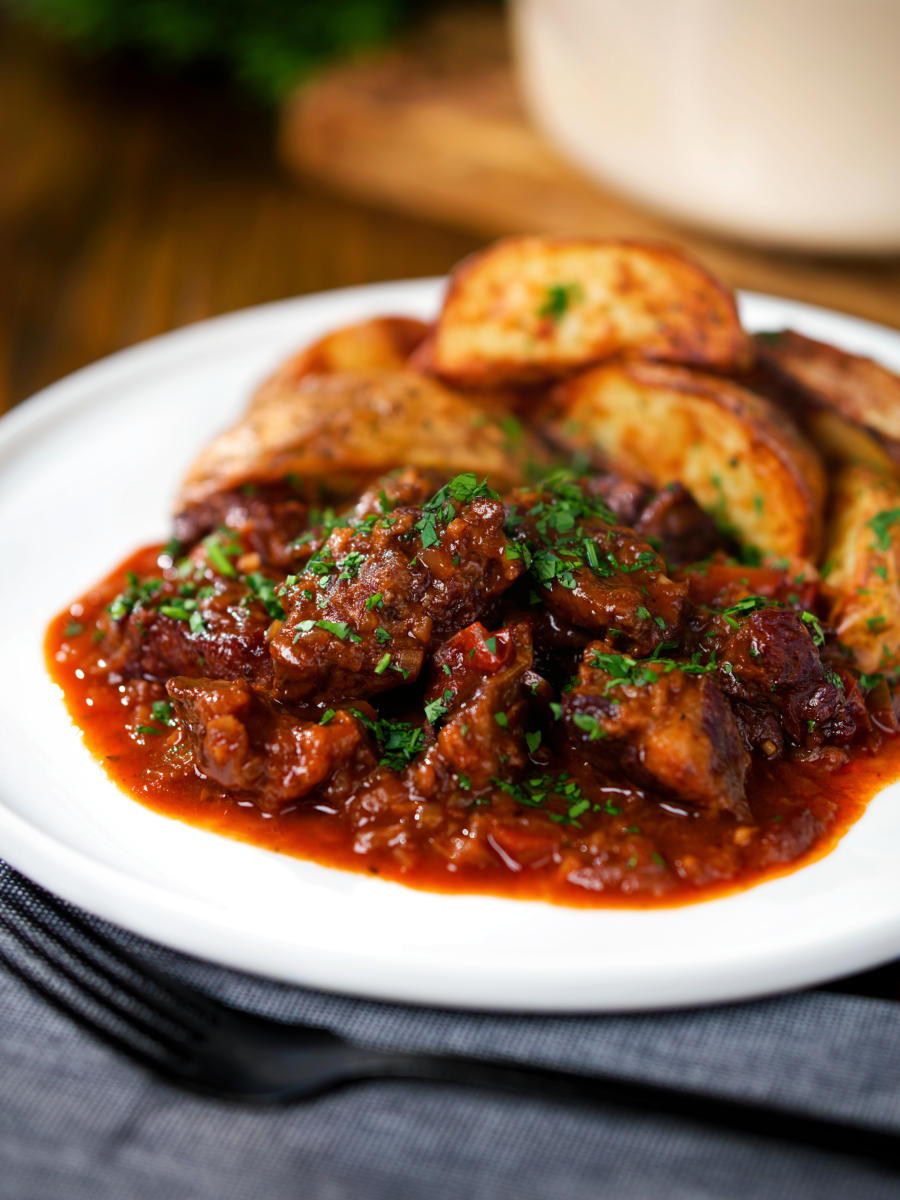 Greek beef kapama stew served with potato wedges.