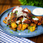 Pan fried Indian masala lamb chops with Bombay potatoes and mint raita.