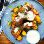 Overhead pan fried Indian masala lamb chops with Bombay potatoes and raita.