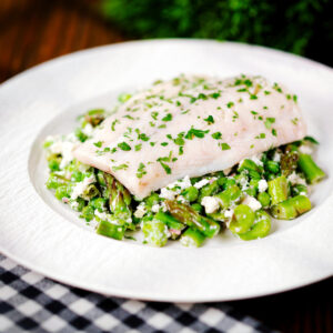 Milk poached smoked haddock fillet served with warm pea and feta salad.