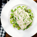 Overhead milk poached smoked haddock served with warm pea and feta salad.