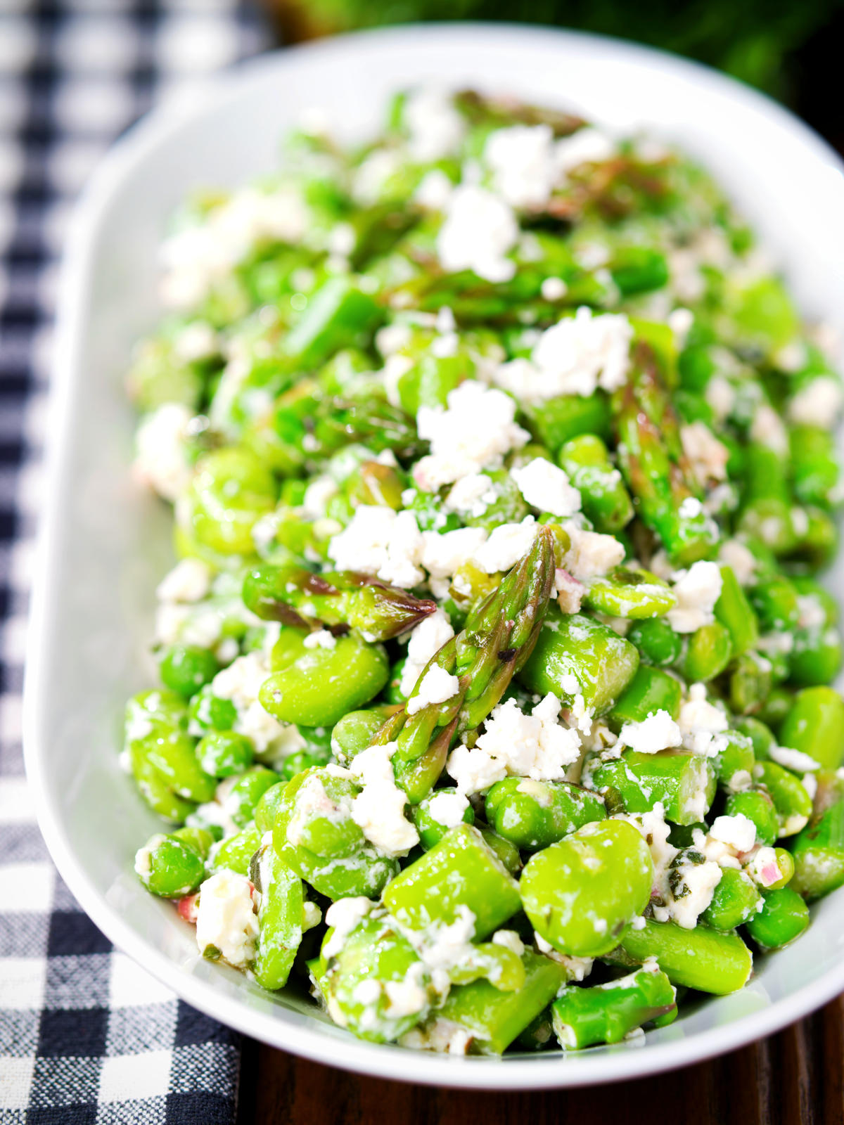 Close-up minted pea and feta salad with asparagus and broad beans.