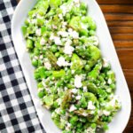 Overhead minted pea and feta salad with asparagus and broad beans.