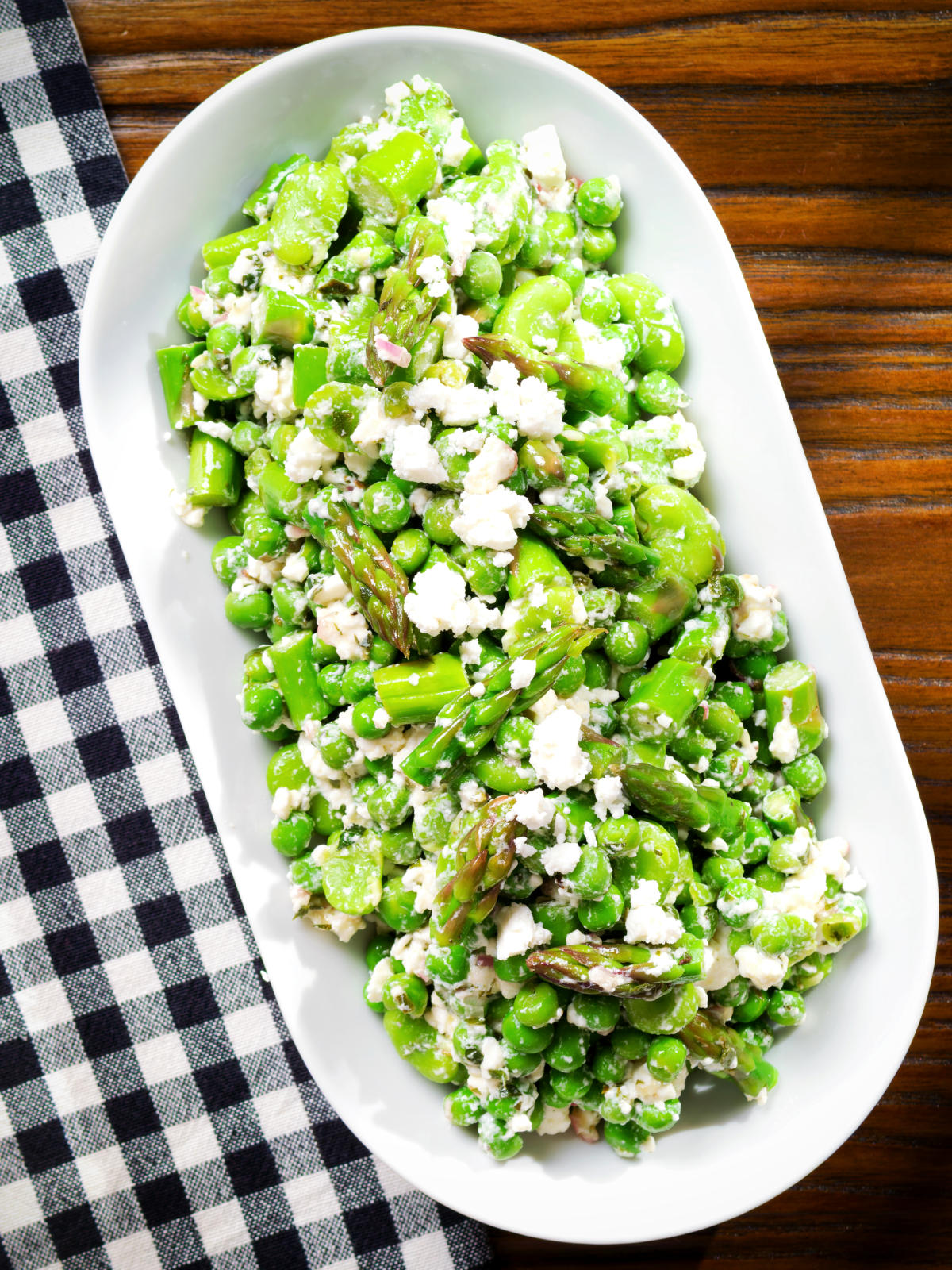 Overhead minted pea and feta salad with asparagus and broad beans.