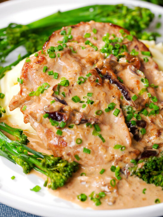 Close-up pork tenderloin with prunes and brandy cream sauce, mashed potato and tenderstem broccoli.