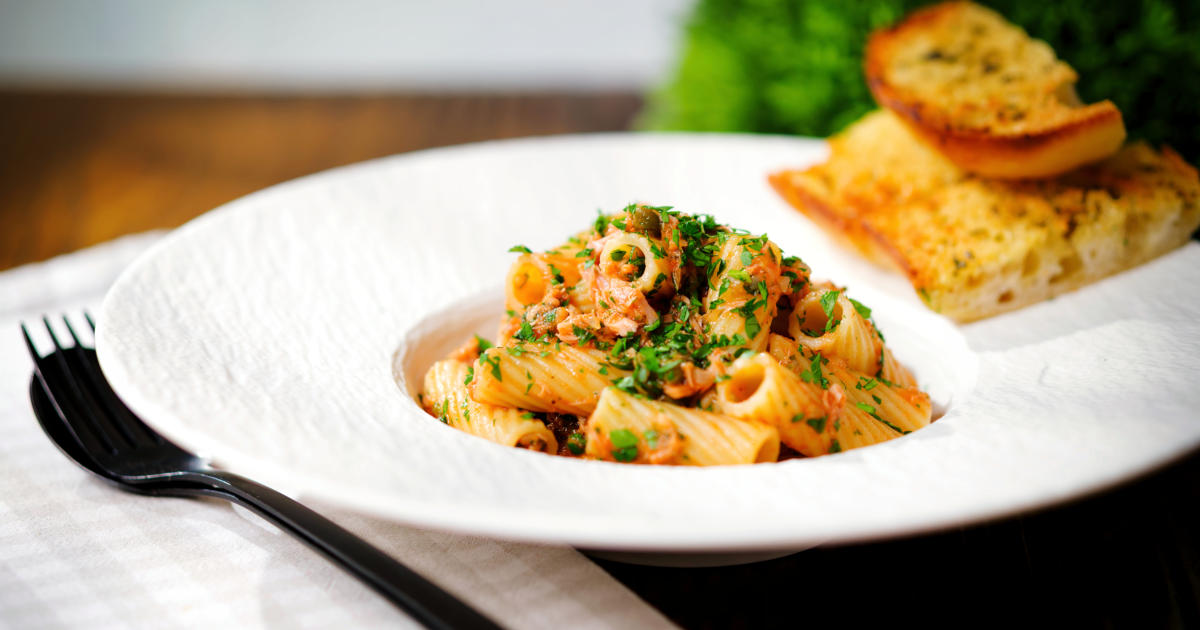 Tinned tuna tomato pasta (rigatoni) with capers, served with garlic bread.