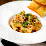 Tinned tuna tomato pasta with capers, served with garlic bread.