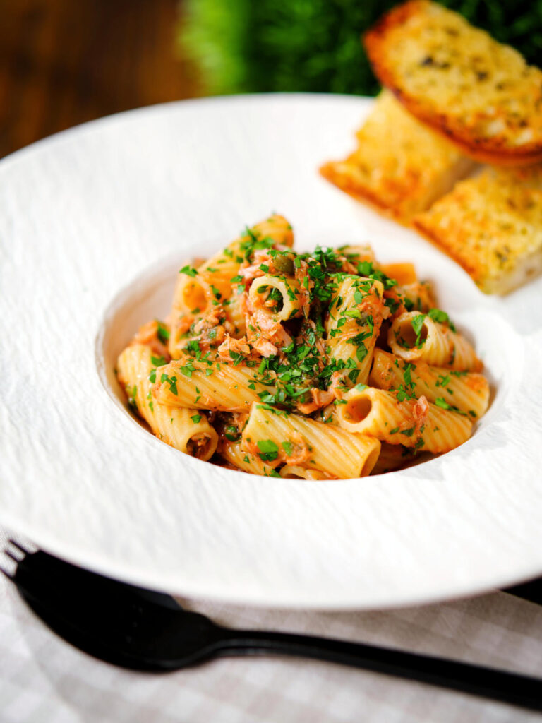 Tinned tuna tomato pasta with capers, served with garlic bread.