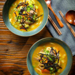 Overhead Japanese curry udon soup with beef and vegetables, nori and spring onions.