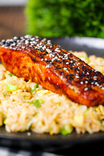 Close-up hoisin sauce glazed salmon fillet served with egg fried rice.