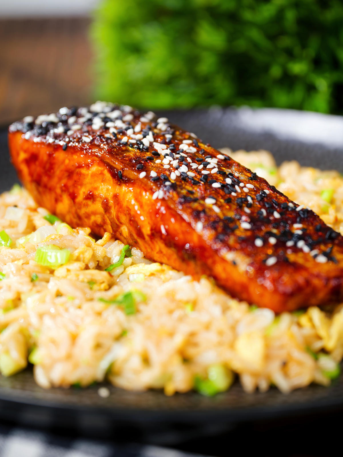 Close-up hoisin sauce glazed salmon fillet served with egg fried rice.