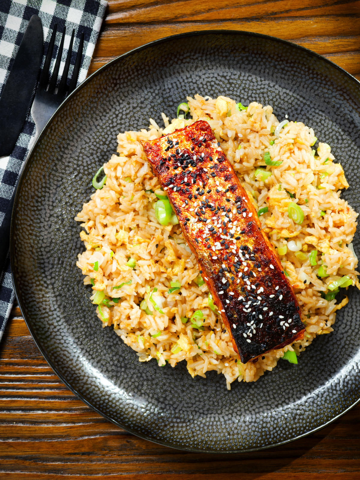 Overhead hoisin sauce glazed salmon fillet served with egg fried rice.