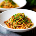 Makaronia me kima (Greek spaghetti bolognese) garnished with fresh parsley.