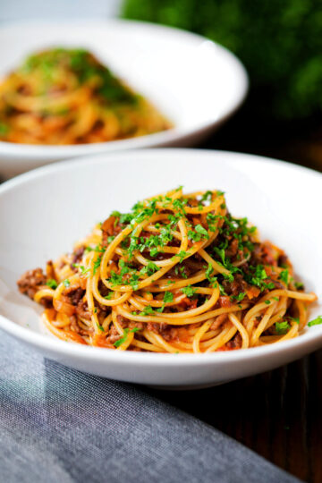 Makaronia me kima (Greek spaghetti bolognese) garnished with fresh parsley.