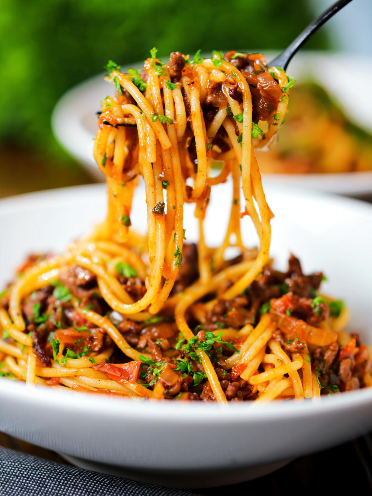 Overhead makaronia me kima (Greek spaghetti bolognese) being picked up with a fork.
