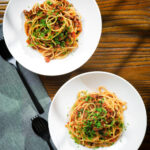 Overhead makaronia me kima (Greek spaghetti bolognese) garnished with fresh parsley.