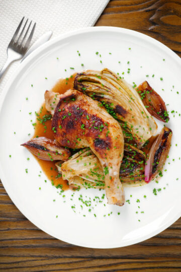 Overhead roasted chicken leg, chicory or Belgian endive and shallots with balsamic gravy.