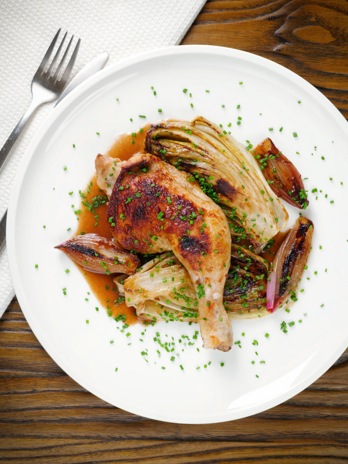 Overhead roasted chicken leg, chicory or Belgian endive and shallots with balsamic gravy.