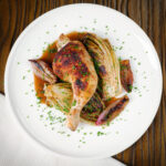 Roasted chicken legs and chicory with shallots and a balsamic gravy served with snipped chives.