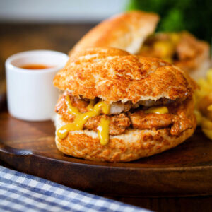 Bifana (Portuguese pork sandwich) served with mustard, French fries and pickles.