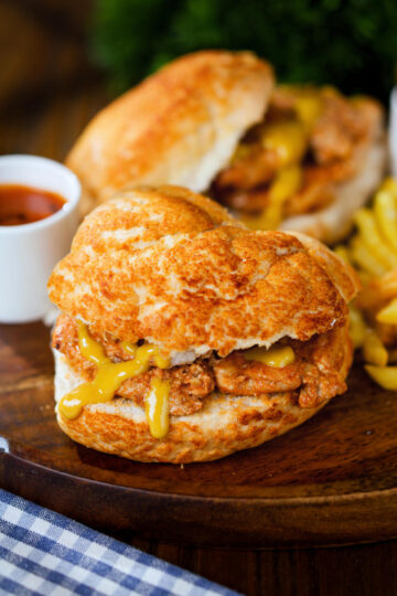 Bifana (Portuguese pork sandwich) with mustard on a bun served with French fries.