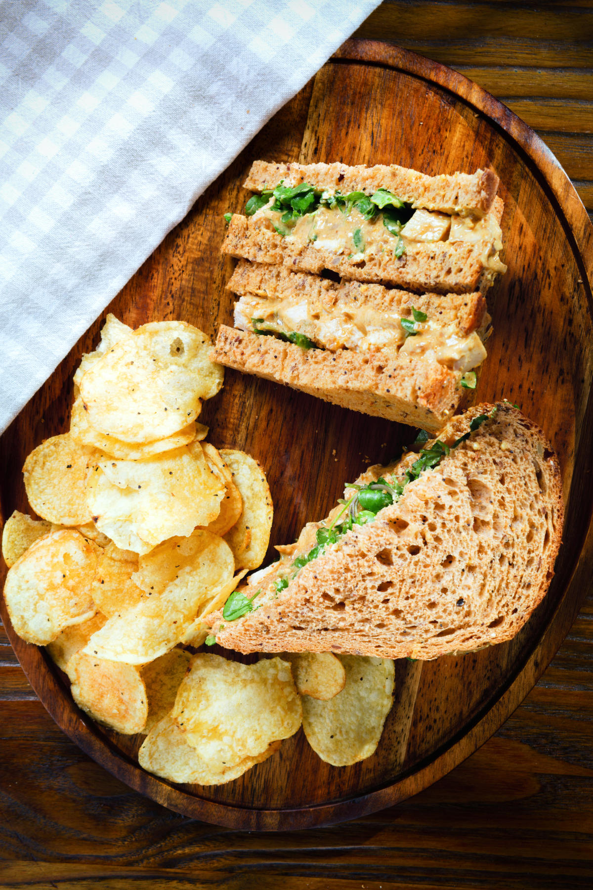 Overhead Coronation chicken sandwich served with potato crisps.