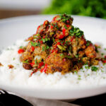 Salt and pepper cauliflower bites with rice, sriracha and coriander.