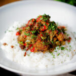 Fried salt and pepper cauliflower bites with rice, sriracha and coriander.