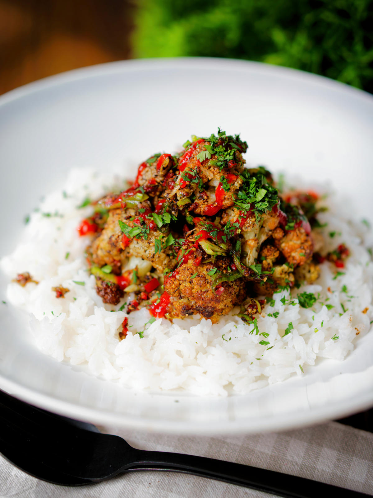 Fried salt and pepper cauliflower bites with rice, sriracha and coriander.