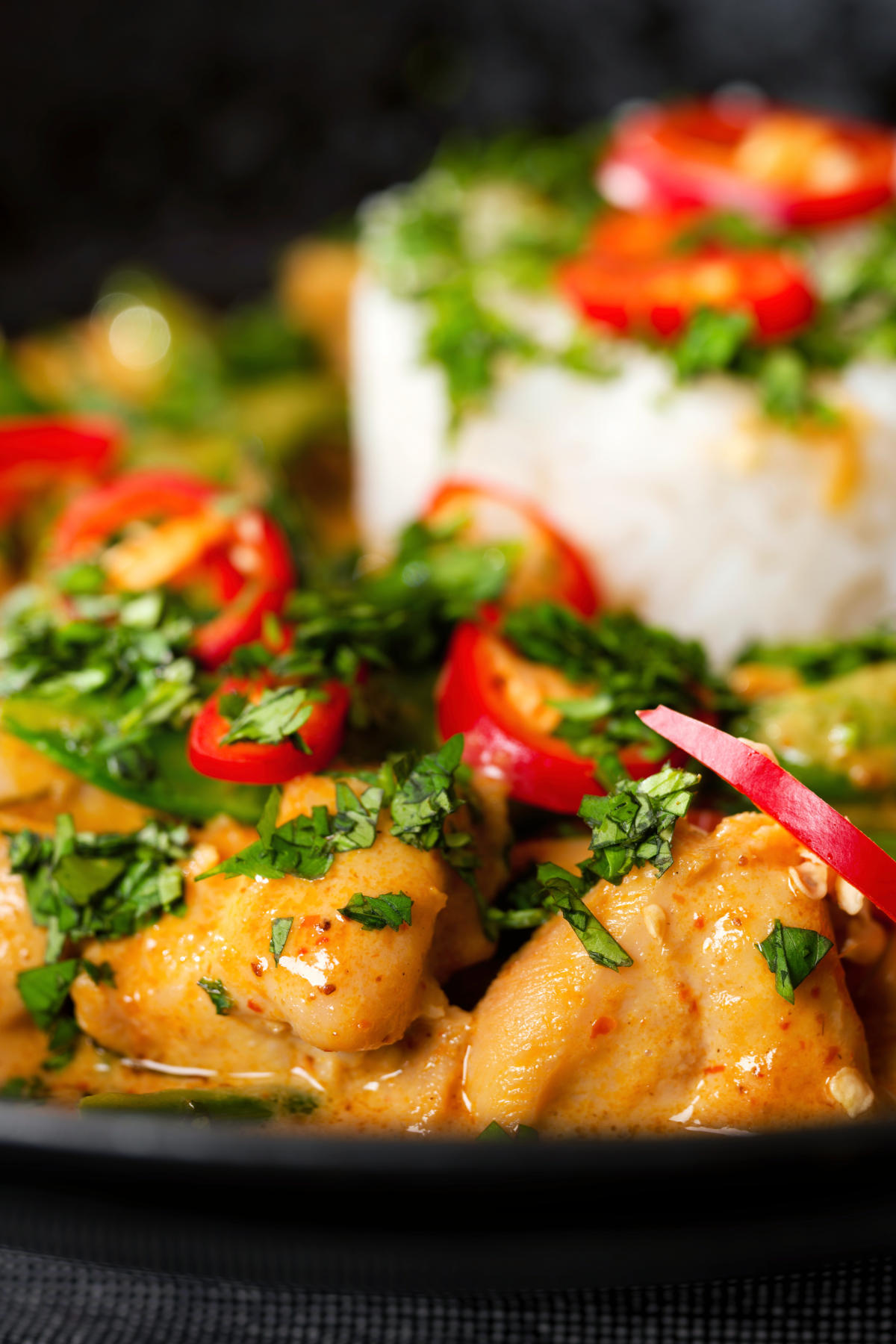 Close-up Thai Panang chicken curry with Jasmine rice, chilli and coriander.