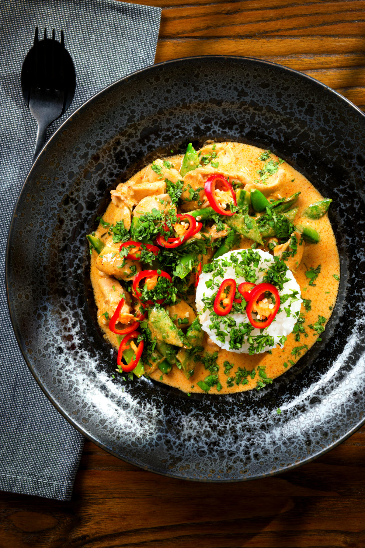 Overhead Thai Panang chicken curry with Jasmine rice, chilli and coriander.
