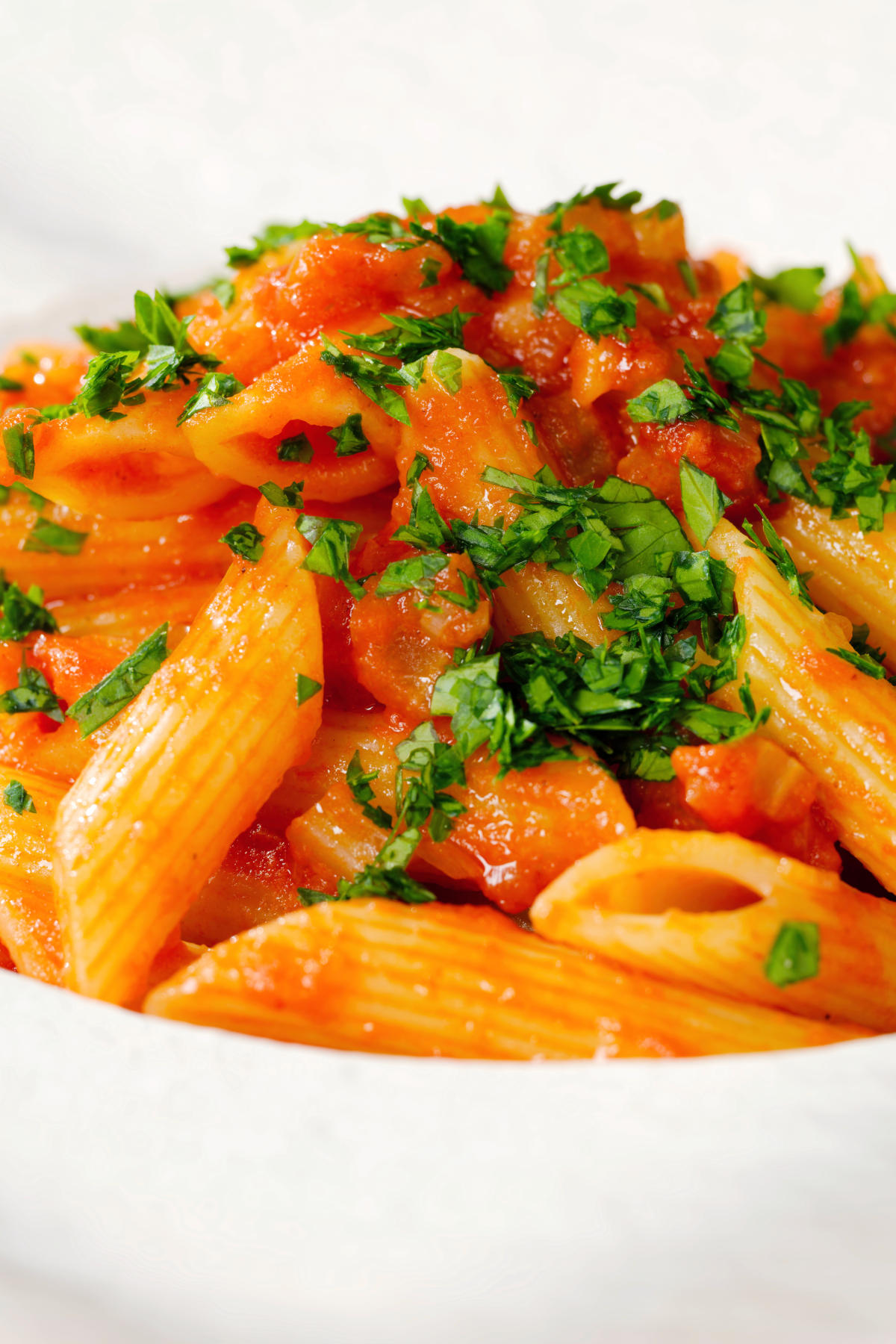 Close-up Bloody Mary Pasta (penne alla vodka), served in a white bowl.