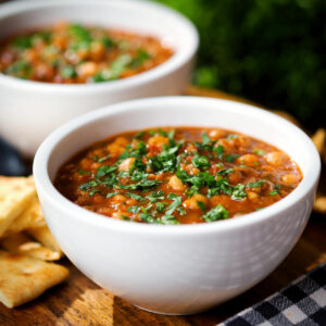 Vegan spicy chickpea and lentil soup served with fresh coriander and crispy flatbread.