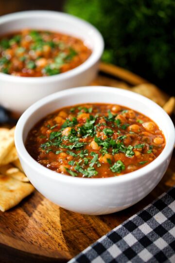 Vegan spicy chickpea and lentil soup garnished with fresh coriander.
