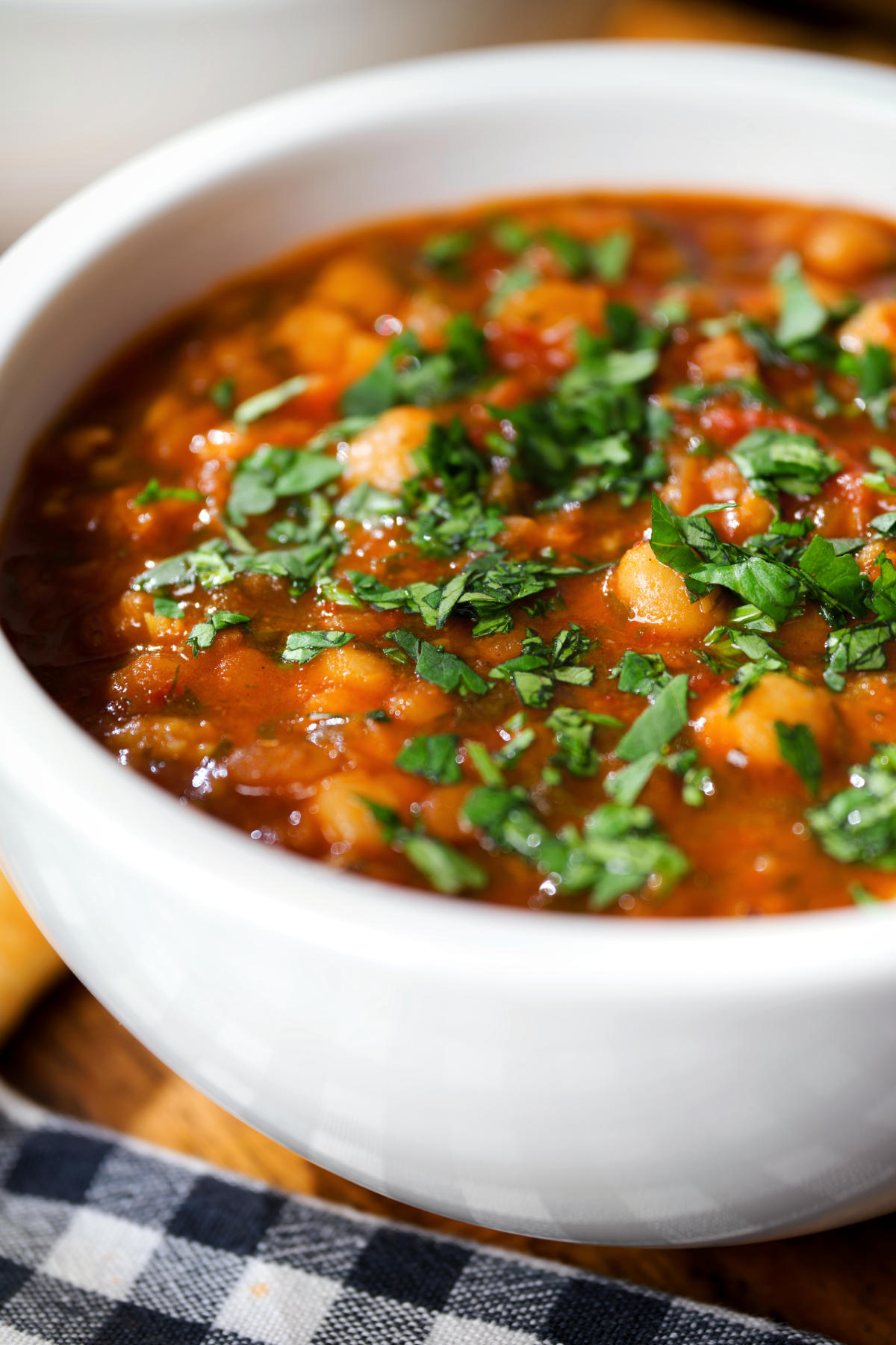 Close-up vegan spicy chickpea and lentil soup garnished with fresh coriander.
