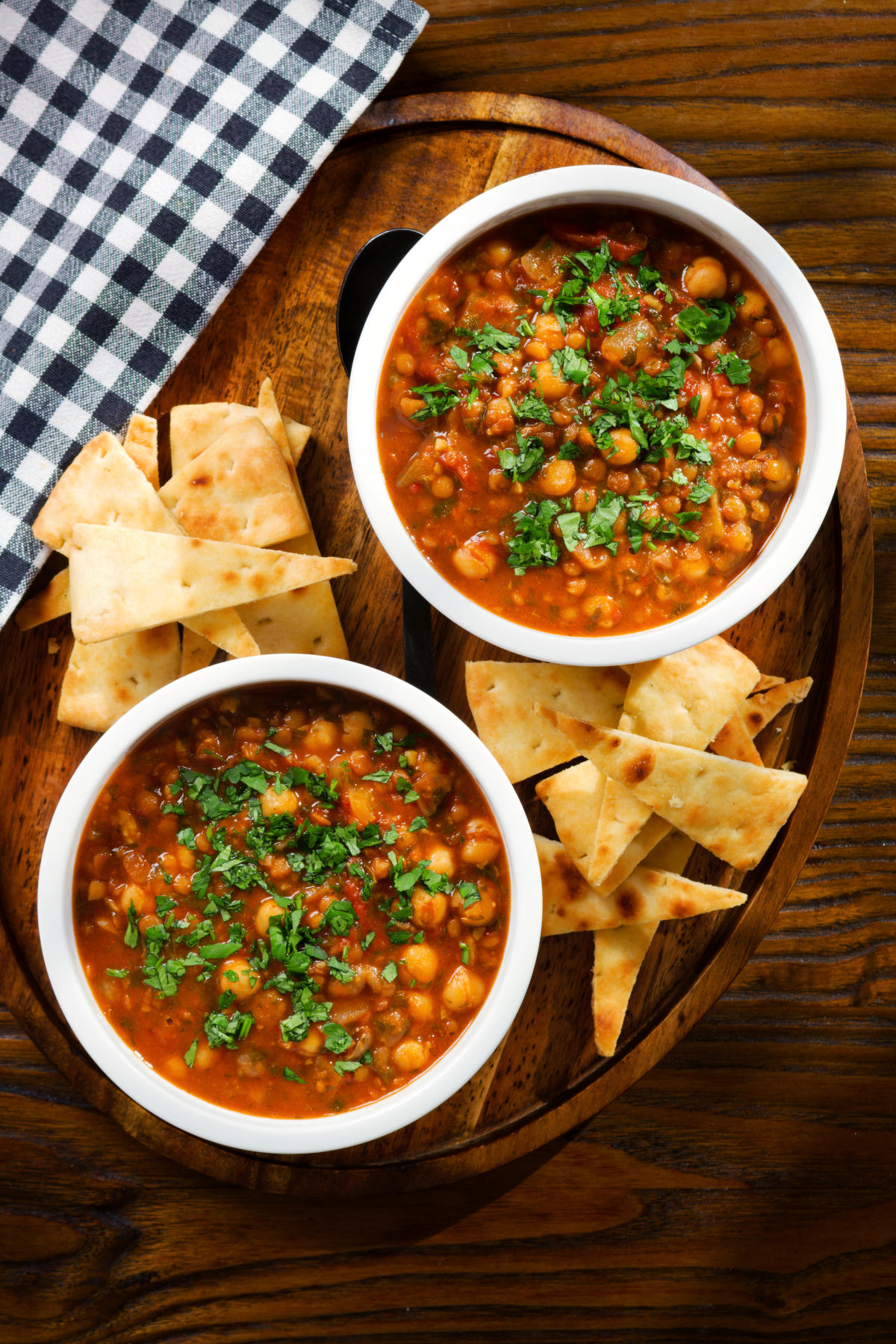 Overhead vegan spicy chickpea and lentil soup garnished with fresh coriander.
