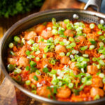 Spicy one-pot sausage and rice with gochujang paste and kimchi, in a cooking pan.