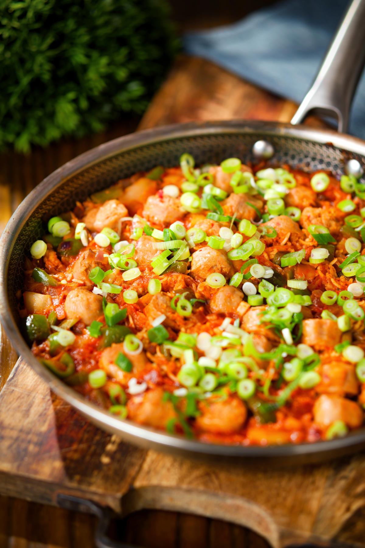 Spicy one-pot sausage and rice with gochujang paste and kimchi, in a cooking pan.