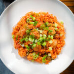 Overhead spicy one-pot sausage and rice with gochujang paste and kimchi.