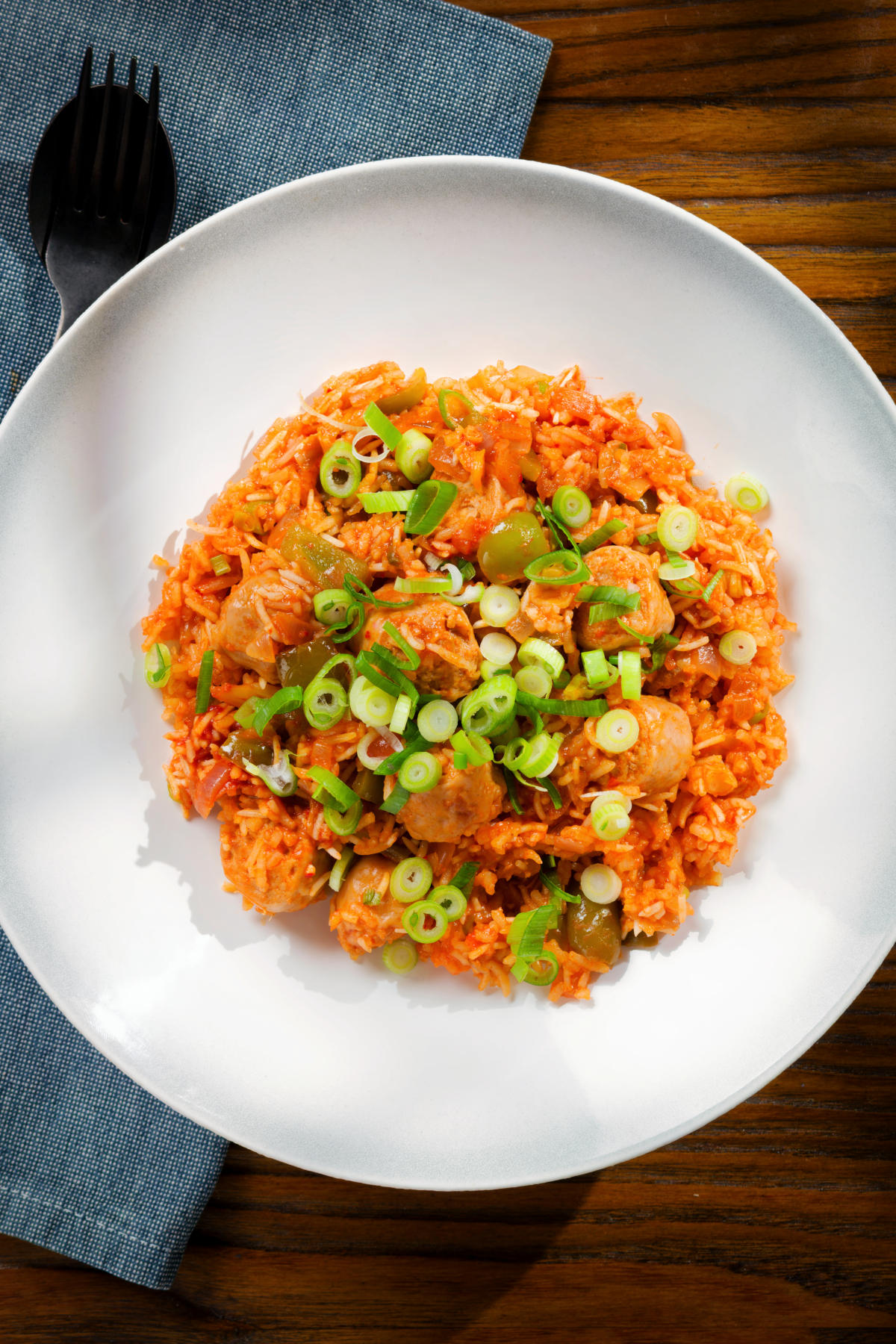Overhead spicy one-pot sausage and rice with gochujang paste and kimchi.