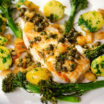 Close-up pan-fried halibut with Grenobloise sauce, buttered potatoes and tenderstem broccoli.