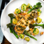 Overhead pan-fried halibut with Grenobloise sauce, buttered potatoes and tenderstem broccoli.