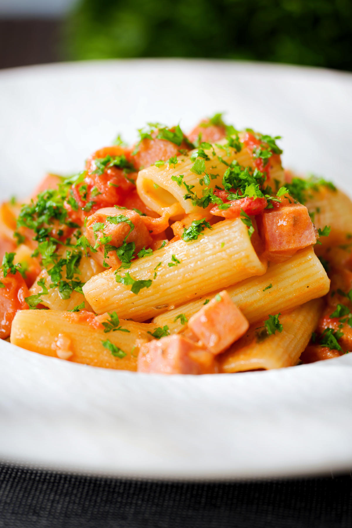 Close-up Spam pasta in a tomato and Dijon mustard sauce.