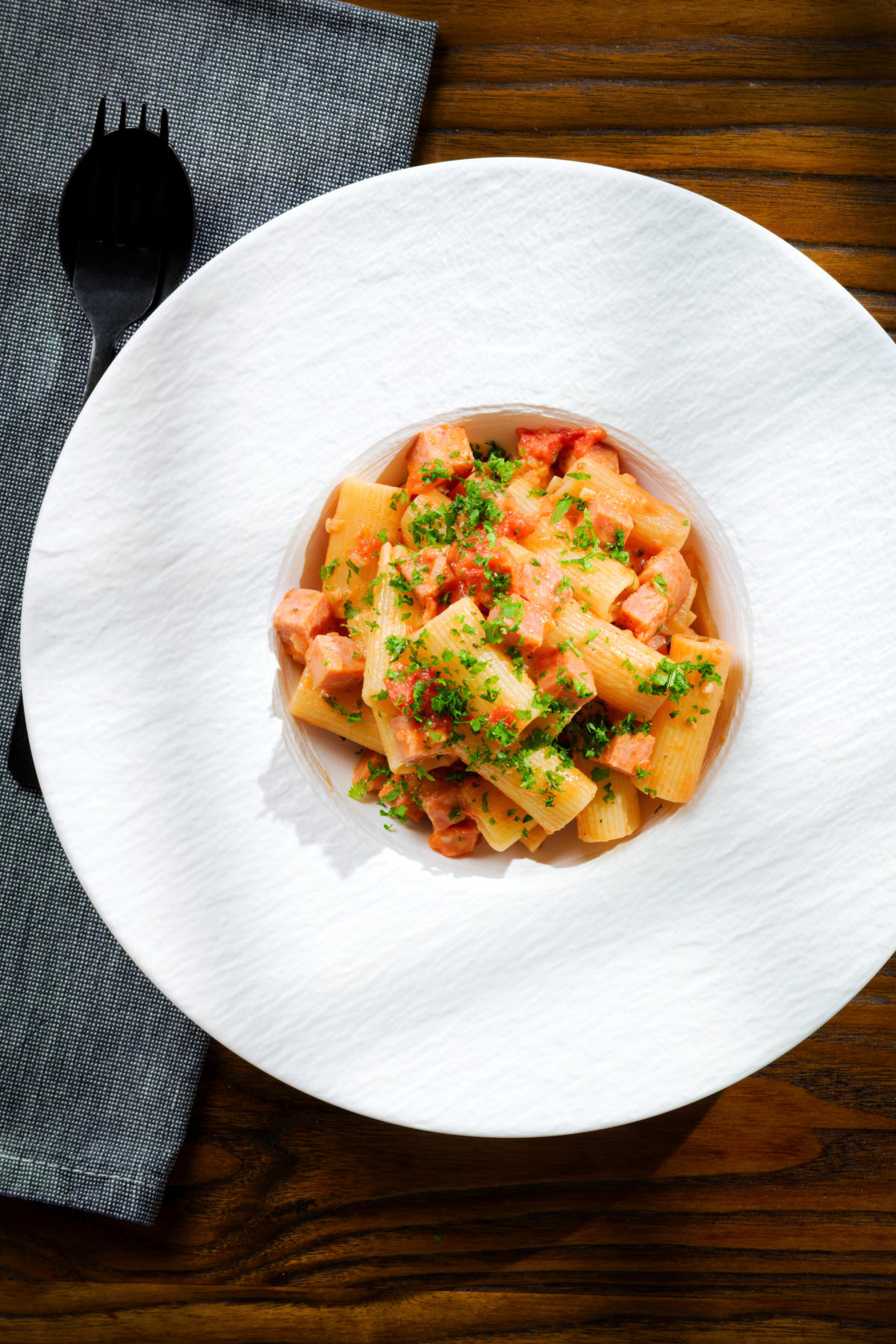 Overhead Spam pasta in a tomato and Dijon mustard sauce.