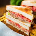 Tinned tomato and sardine salad sandwich served with French fries.