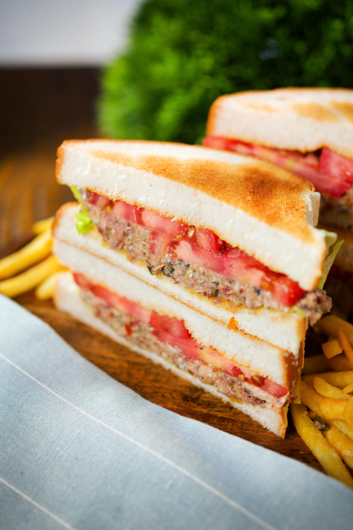 Tomato and tinned sardine salad sandwich served with French fries.
