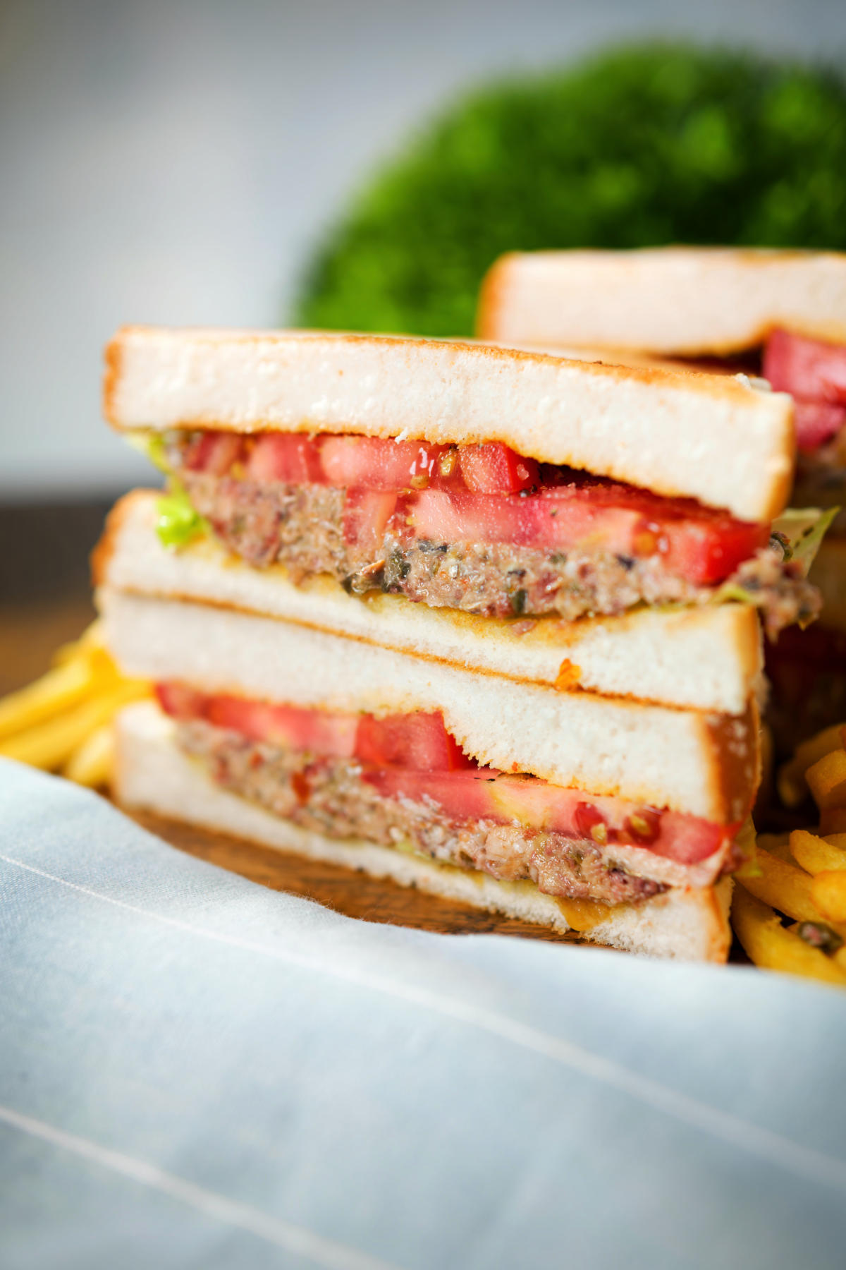 Tomato and canned sardine salad sandwich served with French fries.