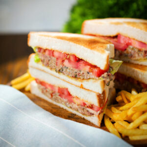 Tinned tomato and sardine salad sandwich on toasted bread served with French fries.